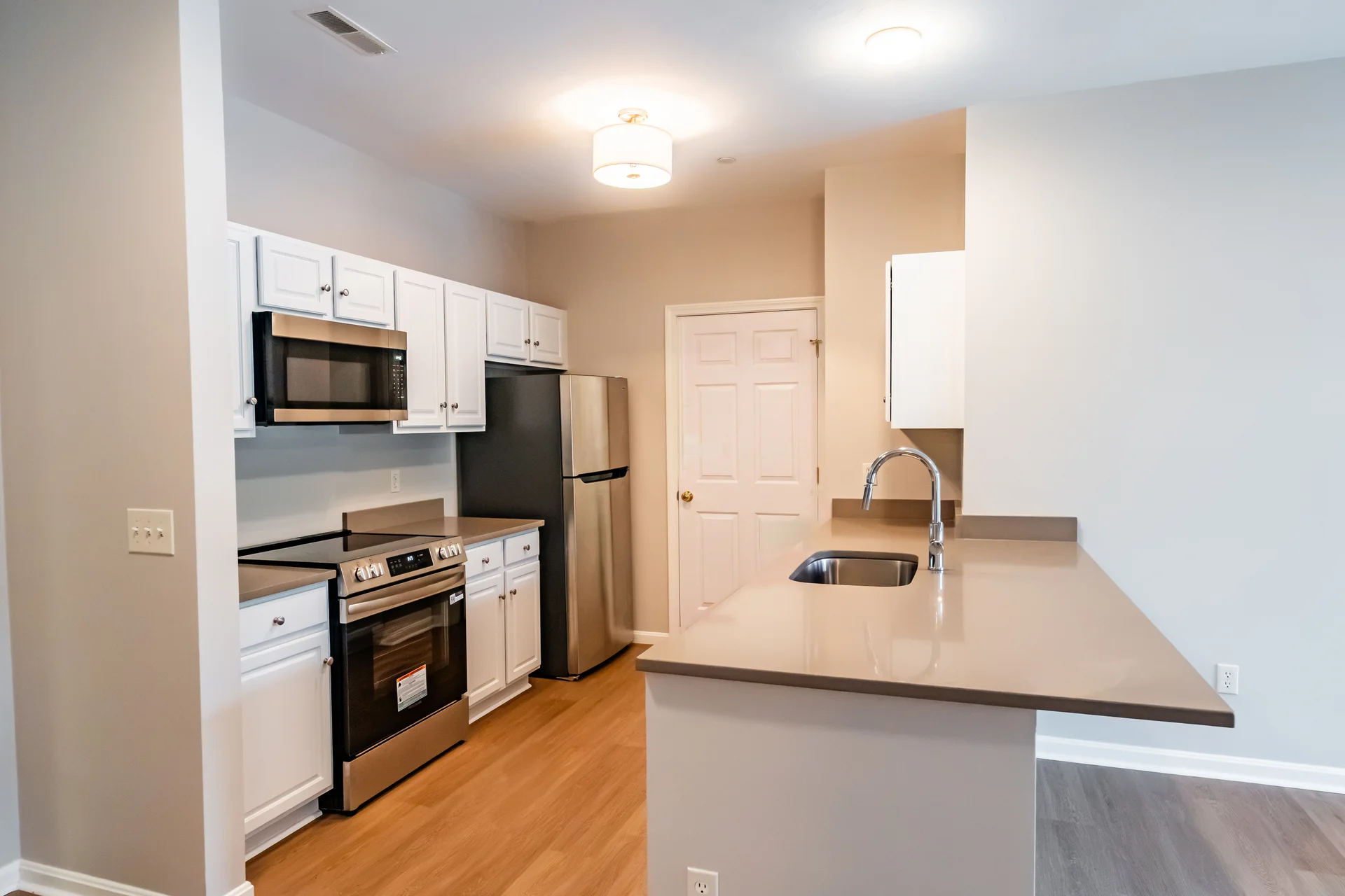 Renovated kitchen with white cabinetry and stainless appliances.